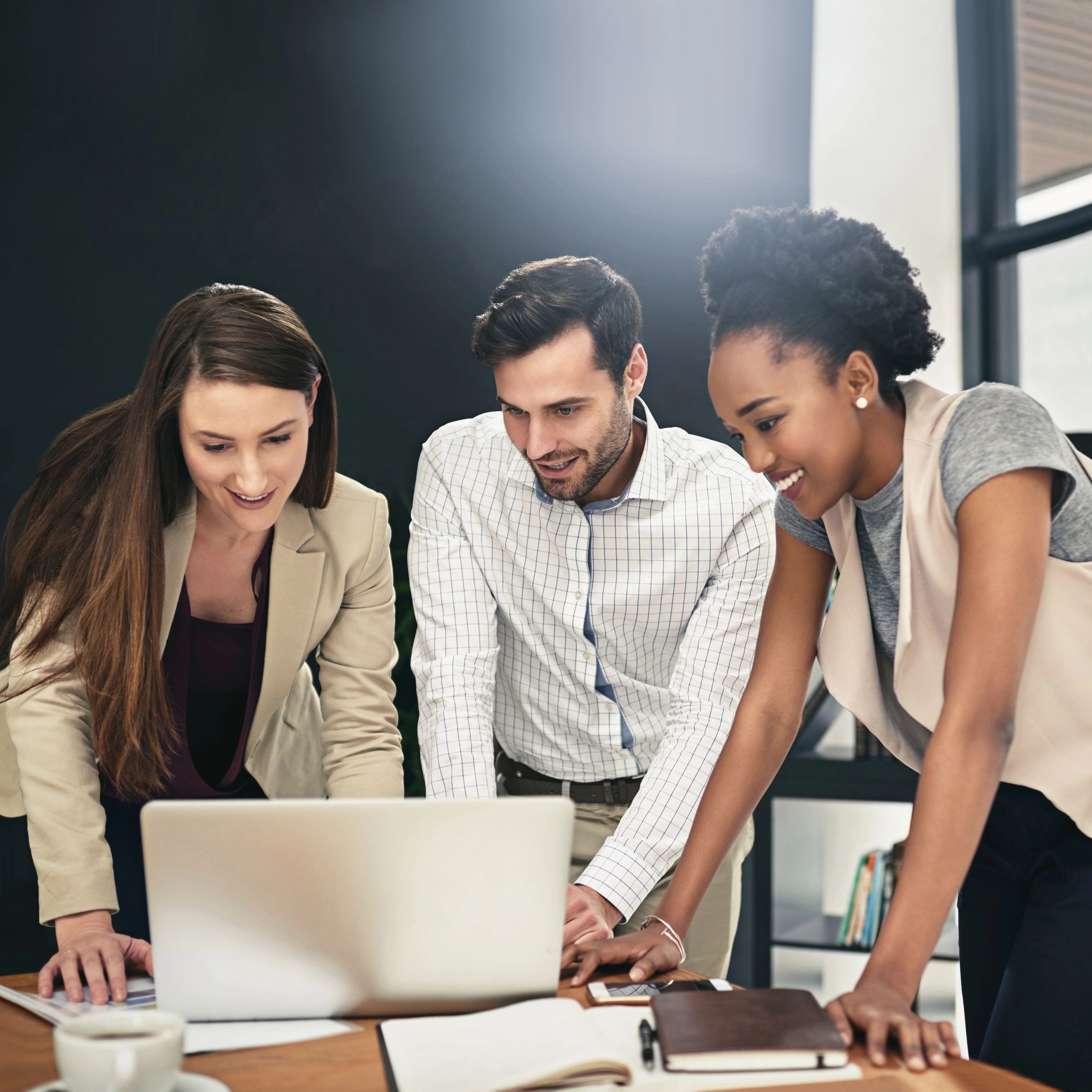 Team collaborating around a laptop